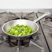 A Vollrath Optio fry pan filled with chopped green peppers on a stove.
