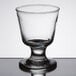 A close up of a Libbey footed rocks glass with a small rim on top.
