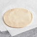 A round Goya empanada dough on white paper.