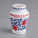 A white Fabbri jar with blue and red designs and strawberries on the label.