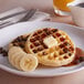 A plate of Kellogg's Eggo Homestyle Waffles with butter and bananas.