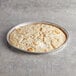 A round white Venice Bakery gluten-free vegan pizza crust in a tin pan.