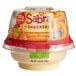 A plastic container of Sabra classic hummus with a white food label and a red lid next to Rold Gold pretzels.