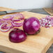A Jumbo red onion sliced on a cutting board.