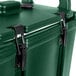 A green Cambro Camtainer cooler with black handles and a latch.