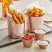 Three Acopa copper cups of fries with red and white sauce.