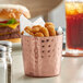 A copper Acopa French fry holder with fries and fried food on a table.