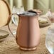 A satin copper stainless steel slender bell pitcher with an ice guard.