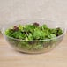 A clear Cambro pebbled serving bowl filled with salad greens.