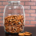 An Anchor Hocking Barrel Jar filled with pretzels on a table.