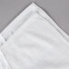 A white Oxford Belleeza bath towel with folded edges on a gray surface.