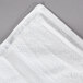 A white Oxford Belleeza bath towel on a gray surface.