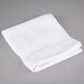 An Oxford Belleeza white washcloth on a gray surface.