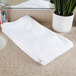 An Oxford Belleeza white bath towel on a counter.