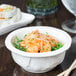 A bowl of shrimp and rice with Huy Fong Sambal Oelek on a table.
