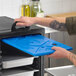 A blue full size ice board being placed into a food pan carrier.