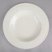 A close-up of a Oneida Espree cream white china pasta bowl with a wavy design.