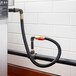 A Regency black gas hose kit with 2 elbows and full port valve attached to a water heater in a food truck.