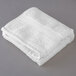 An Oxford Vicenza Bianco white hand towel on a gray surface.