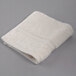 An Oxford Vicenza Avorio white wash cloth with a dobby border on a gray surface.