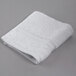 An Oxford Vicenza Bianco white wash cloth with a dobby border on a gray surface.