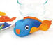 A blue and orange fish sculpture made from Crayola air-dry clay, with a close-up of a paintbrush and a bowl of paint.