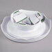 A white plastic Wilton cake stand with a green handle.