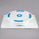 An Ateco white and blue plastic revolving cake stand with blue circles.