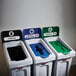 A white Rubbermaid Slim Jim recycling station with green and blue lids.