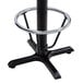 A black metal Lancaster Table & Seating bar height table base with a foot ring.