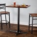 A Lancaster Table & Seating black bar height table base with glasses of beer on it.