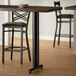 A Lancaster Table & Seating black cast iron bar height table base with FLAT Tech levelers.