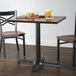 A Lancaster Table & Seating cast iron table base with glasses of beer on it.