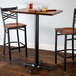 A Lancaster Table & Seating bar height table with two chairs and a mug of beer.