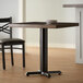 A Lancaster Table & Seating black cast iron table base with self-leveling feet on a table in a restaurant dining area.