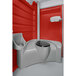 A PolyJohn red portable restroom with a sink and toilet.