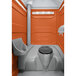 An orange PolyJohn portable restroom with a translucent top.