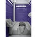 A PolyJohn portable restroom with a toilet and sink in a purple interior.