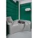 A PolyJohn portable restroom with a green wall and seat.