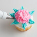 A cupcake with blue and white frosting decorated with a flower using an Ateco Leaf piping tip.