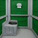 A green PolyJohn wheelchair accessible portable restroom with a black toilet seat.