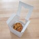 A Baker's Mark white jumbo cupcake box with a muffin inside.