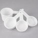 A group of three white Rubbermaid plastic measuring cups with handles.