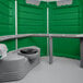 A green and white PolyJohn wheelchair accessible portable restroom with a toilet and sink.