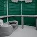 A green and white PolyJohn wheelchair accessible portable restroom with a grey toilet and sink inside.