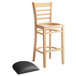 A Lancaster Table & Seating wooden bar stool with a detached black cushion seat.
