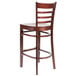 A Lancaster Table & Seating mahogany wood bar stool with a ladder back.