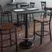 A Lancaster Table & Seating black cast iron bar height table base with a foot ring.