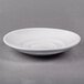 A white porcelain saucer with a rim on a white surface.