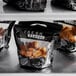 A group of 4 piece small black and white resealable bags of fried chicken.